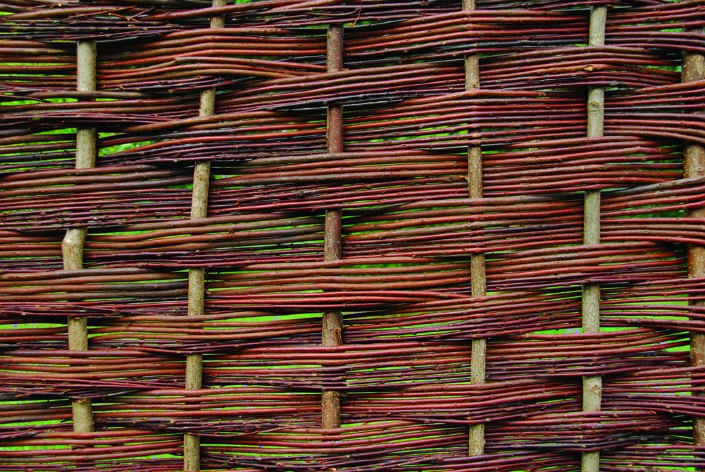 Close woven willow hurdle in deep russet red-brown, showing the tight even weave